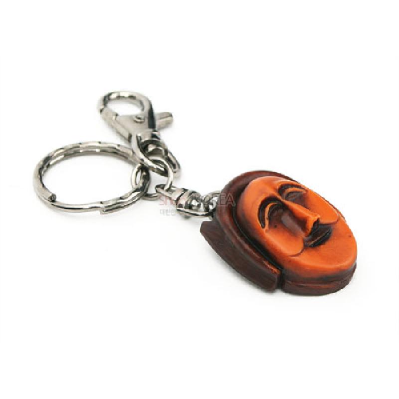 주황과 갈색 톤의 부네탈 형상 수지 장식에 금속 고리를 연결한 열쇠고리.