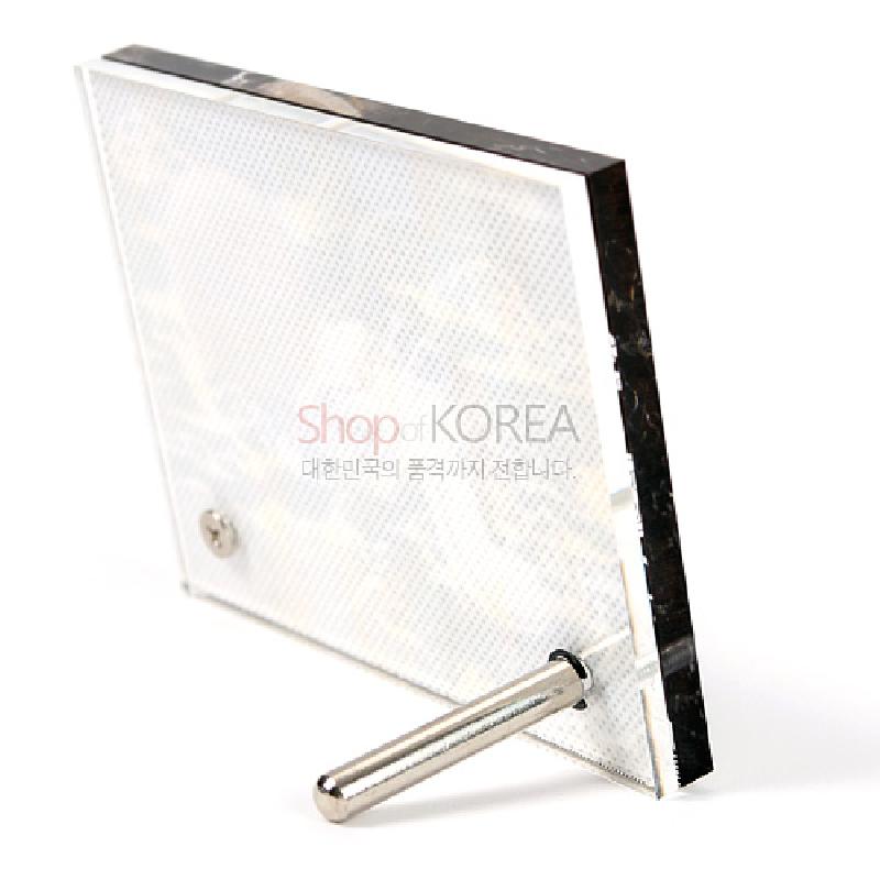 투명 아크릴 재질의 사각 프레임과 금속 지지대를 사용한 미세 패턴 배면 장식 탁상용 시계.