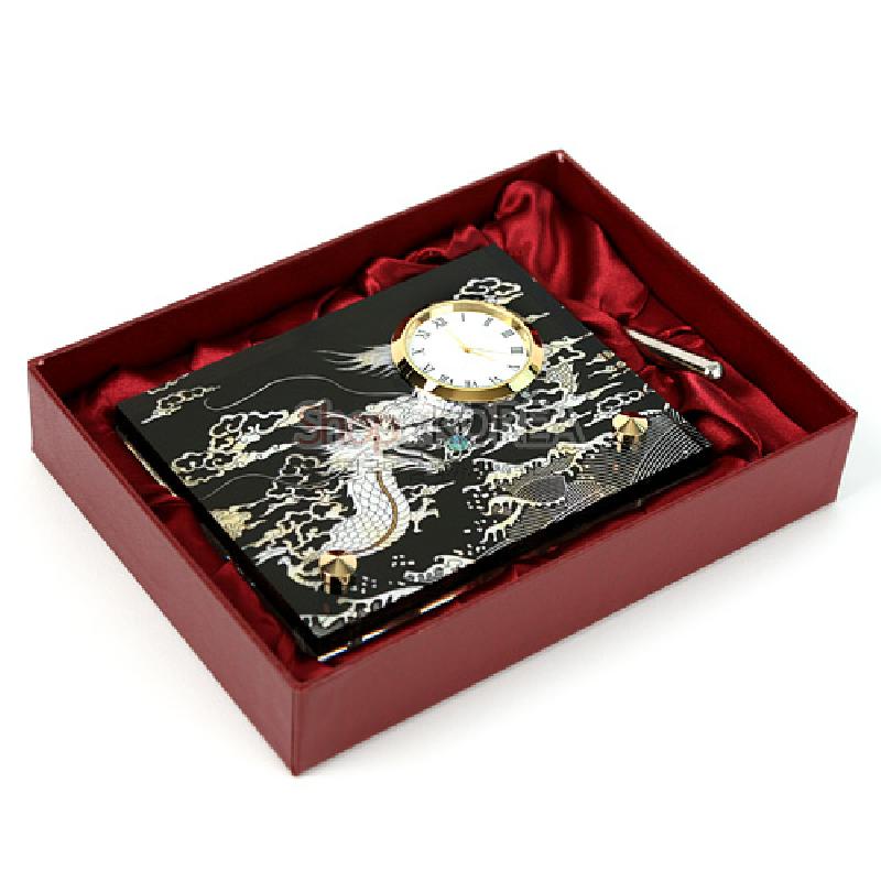 검은 옻칠 바탕에 자개 상감으로 용과 구름 문양을 넣은 탁상용 시계, 금색 금속 테두리와 붉은 비단 안감 상자 구성.