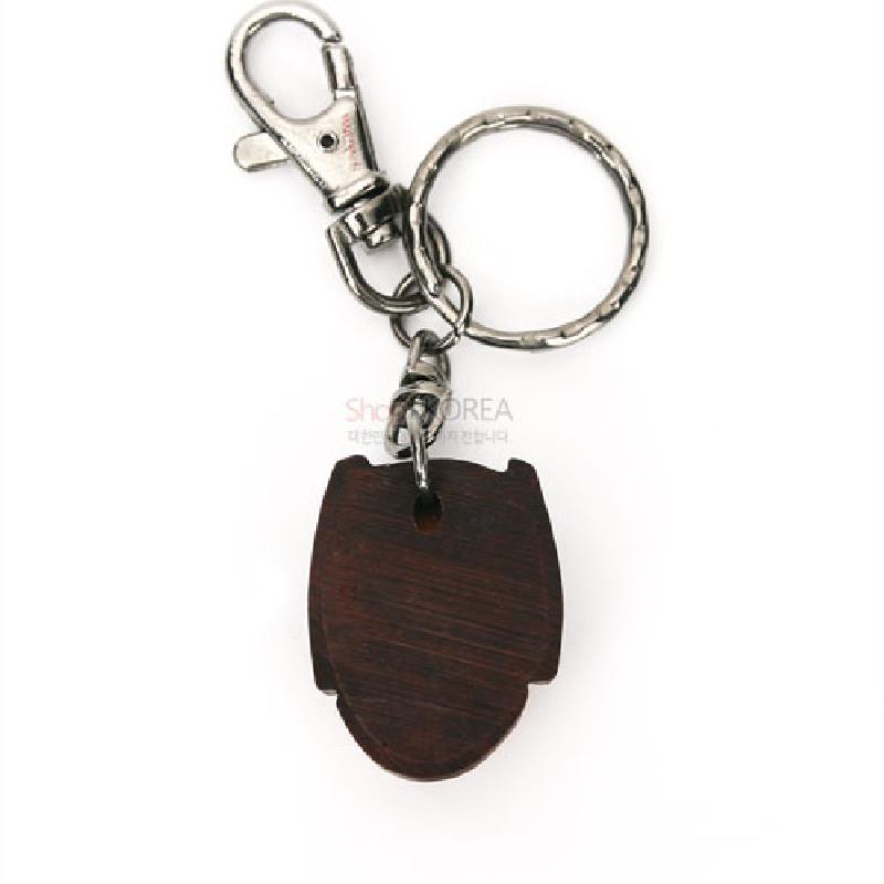 짙은 갈색 나무 소재의 부네탈 모양 장식과 금속 링, 고리 장식이 결합된 열쇠고리.