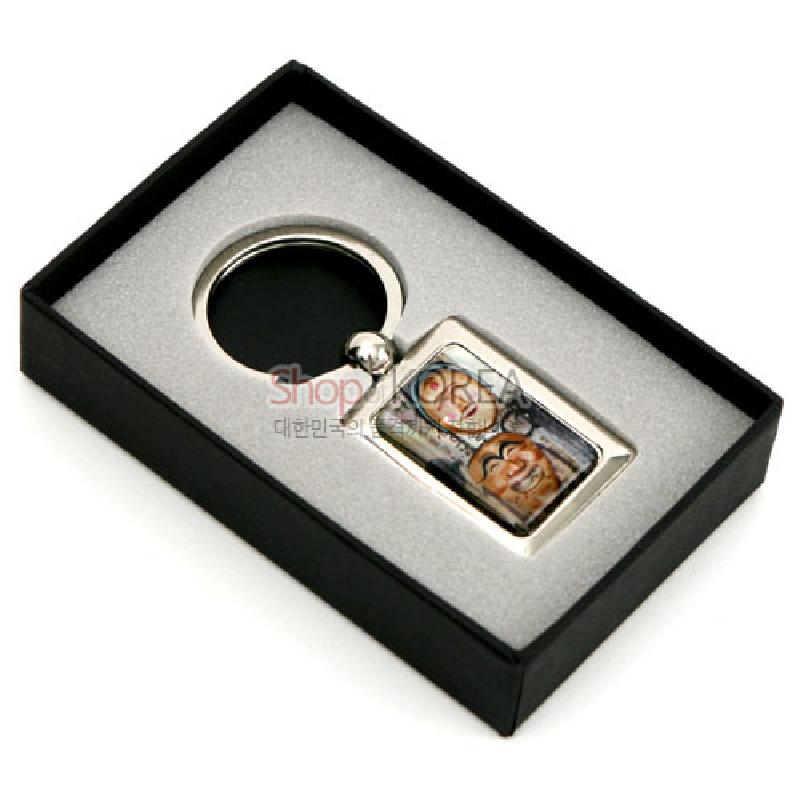 금속 테두리에 자개 상감 기법으로 하회탈 문양을 넣은 사각 장식 열쇠고리.