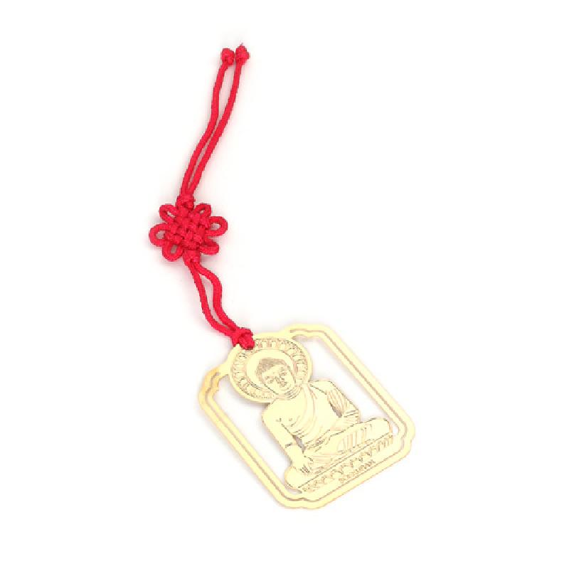 금속 재질의 금장 석굴암 본존불 음각 장식과 붉은 전통 매듭 끈이 어우러진 직사각형 책갈피. 금속 재질의 금장 석굴암 본존불 음각 장식과 붉은 전통 매듭 끈이 어우러진 직사각형 책갈피.