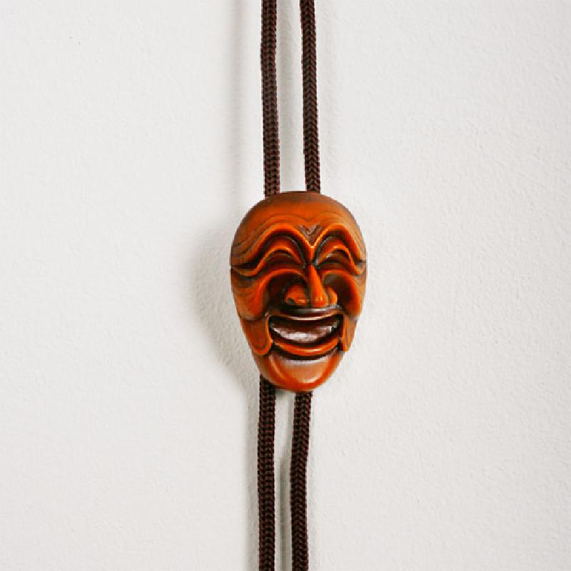 나뭇결이 살아 있는 목재 재질의 양반탈 조각 장식과 갈색 직조 로프로 구성된 로프타이.