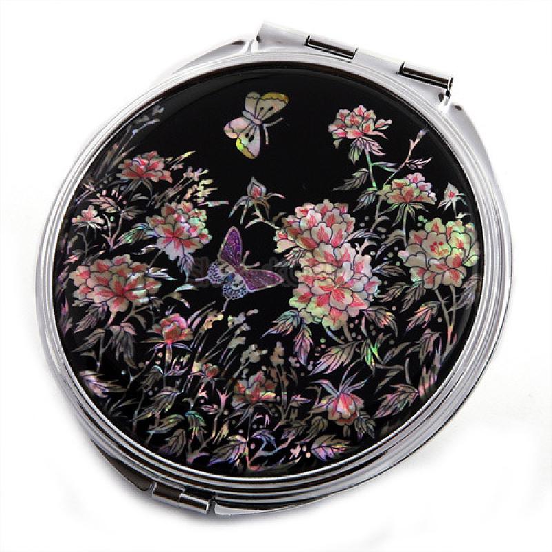 나전칠기 손거울의 측면 각도. 은색 테두리와 검은 옻칠 바탕 위 자개 목단나비 문양의 광택이 돋보임.