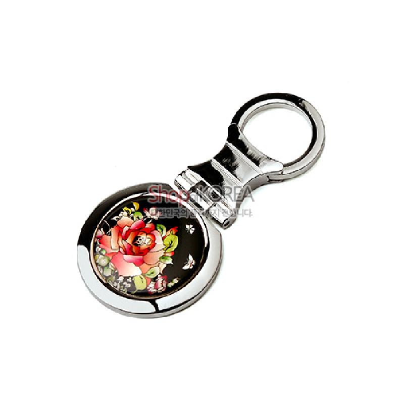 검은 바탕 위 자개 상감 장미와 나비 문양이 들어간 원형 메달, 은색 금속 고리 결합 열쇠고리.