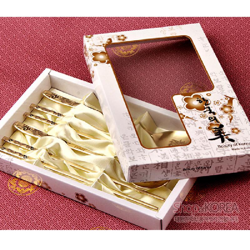 티타늄 소재의 수저 세트, 손잡이에 용 문양과 한글 패턴을 금색으로 장식한 디자인, 아이보리색 실크 안감 포장.