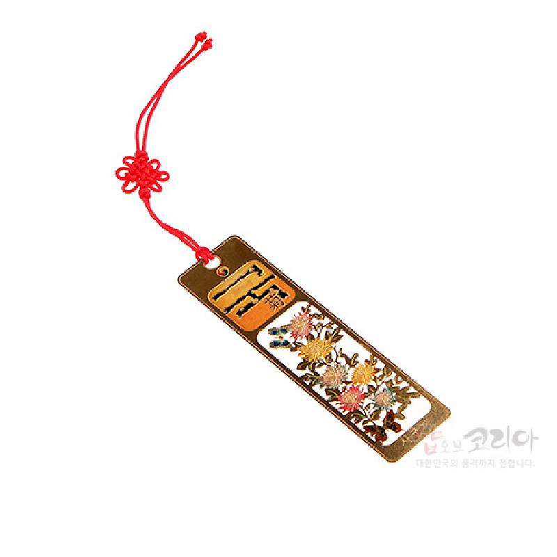 금속 소재에 국화와 나뭇가지가 섬세하게 투각된 문양, 붉은색 전통 매듭 끈 장식의 책갈피.