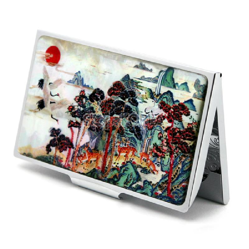 나전 자개 위에 십장생 민화 풍경을 채색한 금속 명함집, 붉은 해와 학·사슴·소나무가 어우러진 다채로운 색감의 장식. 나전 자개 위에 십장생 민화 풍경을 채색한 금속 명함집, 붉은 해와 학·사슴·소나무가 어우러진 다채로운 색감의 장식.