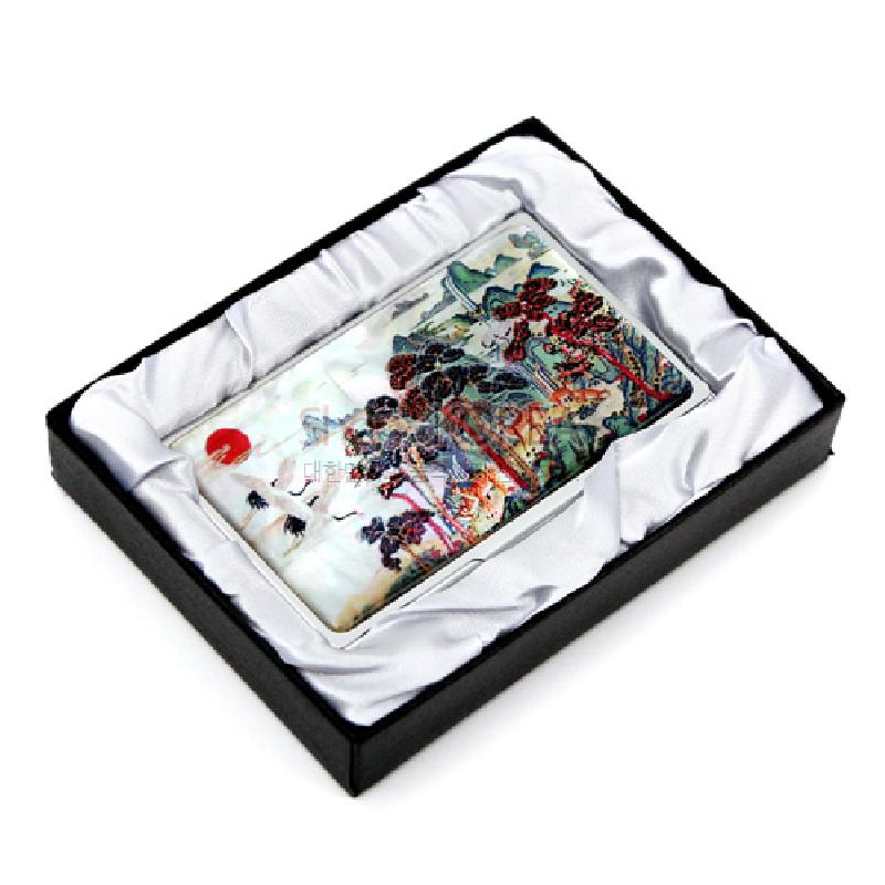 자개 상감 기법으로 표현된 십장생 민화 문양과 붉은 해가 어우러진 다채로운 색상의 금속 명함집. 자개 상감 기법으로 표현된 십장생 민화 문양과 붉은 해가 어우러진 다채로운 색상의 금속 명함집.