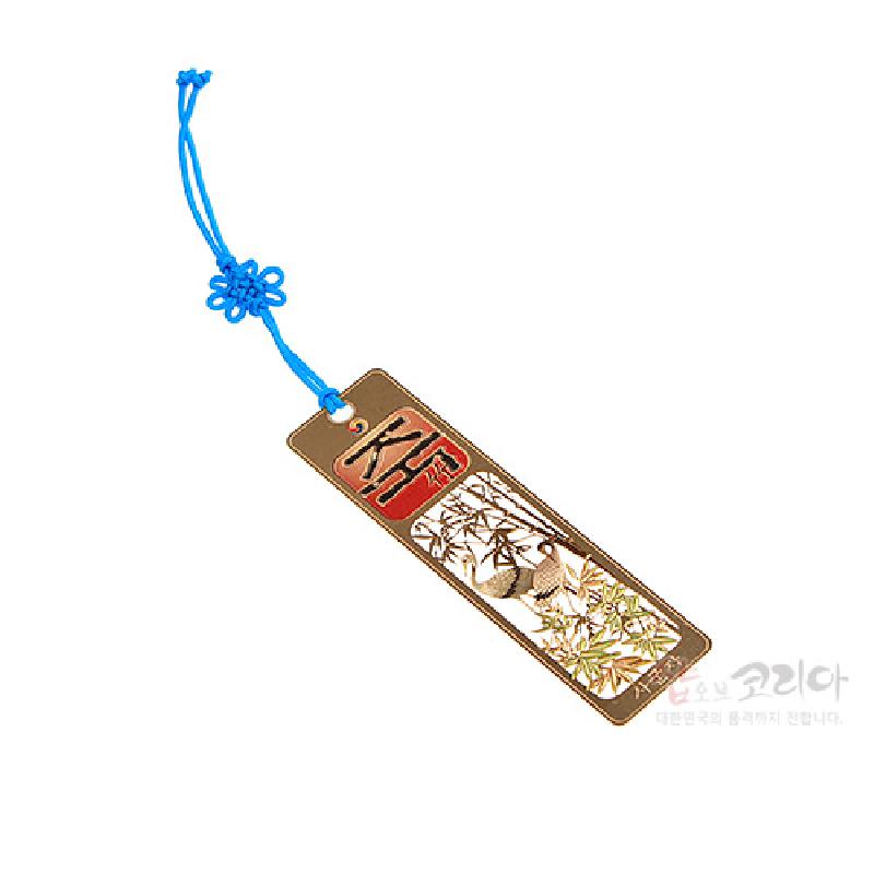 금속 재질에 금장으로 새긴 대나무와 새 문양, 붉은색 한자 장식과 파란 매듭 끈이 어우러진 책갈피.