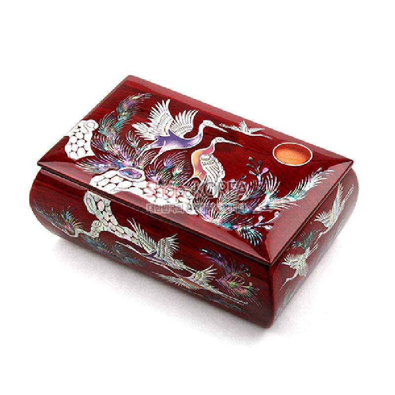붉은 옻칠 바탕에 자개 상감 기법으로 송학과 소나무, 해 문양을 섬세하게 표현한 반지꽂이 상자.