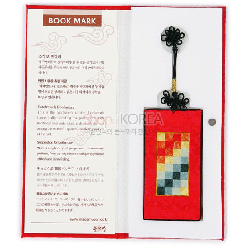조각보 기법의 다색 패치워크 문양과 적색 바탕이 돋보이는 천 소재 책갈피.