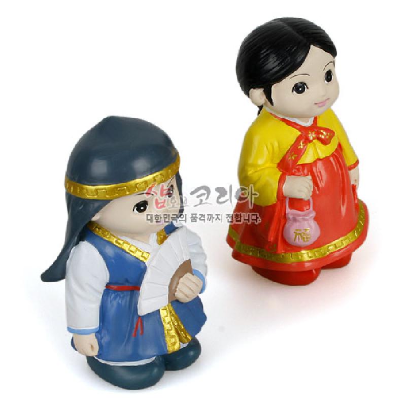 채색 플라스틱 재질의 춘향·몽룡 한복 인형, 원색 대비와 황금색 띠 장식, 전통 부채와 복주머니 표현. 채색 플라스틱 재질의 춘향·몽룡 한복 인형, 원색 대비와 황금색 띠 장식, 전통 부채와 복주머니 표현.