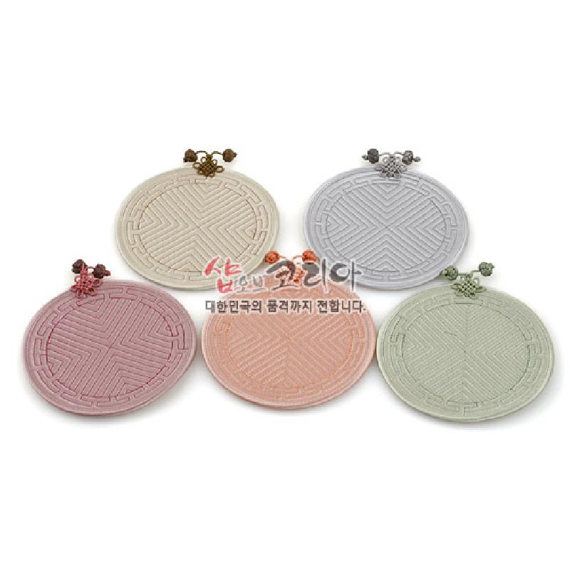 전통 누비 기법으로 완자문을 수놓은 파스텔톤 원형 컵받침과 실매듭 장식의 패브릭 소품.