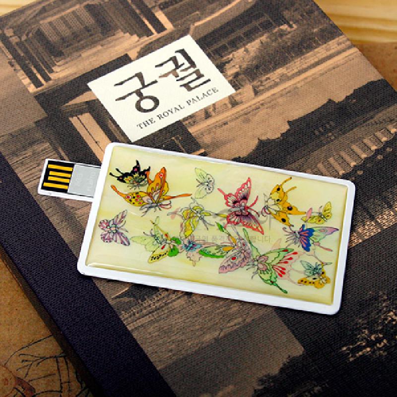 연한 상아색 바탕 위 다채로운 나비 문양이 그려진 카드형 자개 USB 메모리. 연한 상아색 바탕 위 다채로운 나비 문양이 그려진 카드형 자개 USB 메모리.