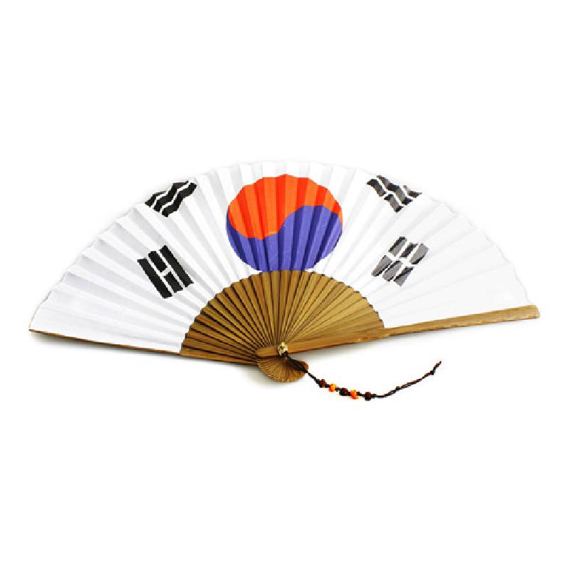 흰색 종이 위에 태극 문양과 사괘가 인쇄된 접선, 대나무 살과 오색 매듭 장식이 어우러진 부채.