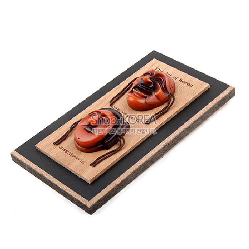 나무 판 위에 갈색과 흑갈색의 하회탈 두 개를 부착한 입체 조각 장식 액자. 나무 판 위에 갈색과 흑갈색의 하회탈 두 개를 부착한 입체 조각 장식 액자.