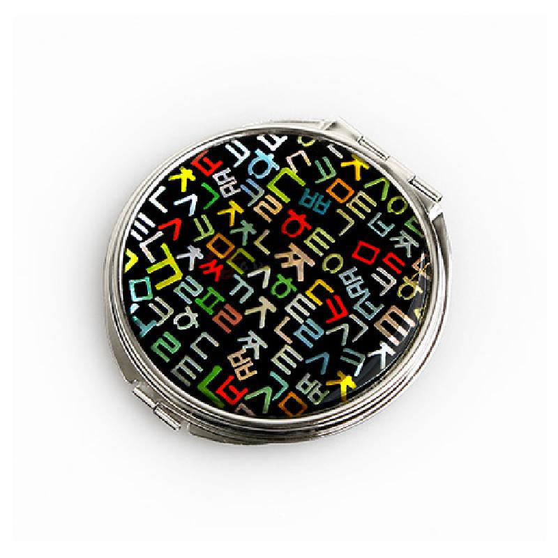 검은 바탕 위에 다채로운 색상의 훈민정음 자음 문양을 상감한 금속 테두리 자개 손거울. 검은 바탕 위에 다채로운 색상의 훈민정음 자음 문양을 상감한 금속 테두리 자개 손거울.