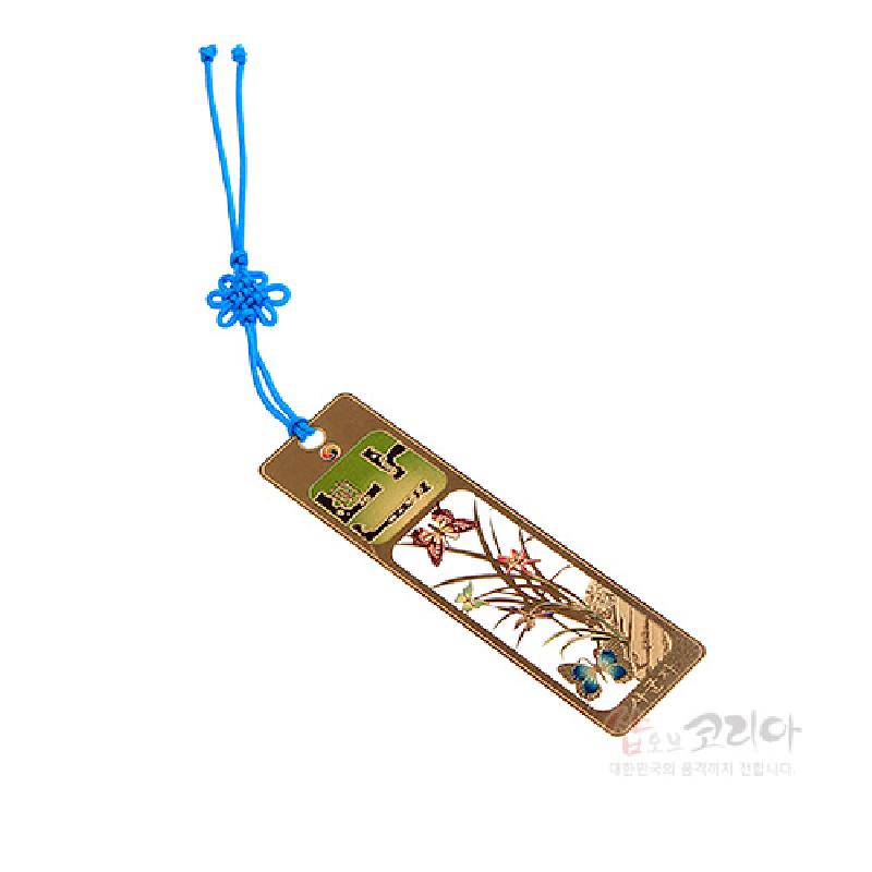 금속 재질에 색채 채색으로 표현된 난초와 나비 문양, 상단에 전통 문자 장식을 더하고 파란 전통 매듭끈이 연결된 책갈피.