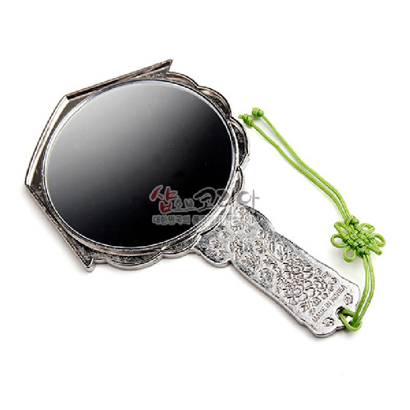 은색 금속 소재에 꽃문양 양각 장식과 연두색 전통 매듭 끈이 더해진 손거울.