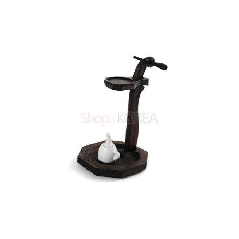 짙은 갈색 나무 재질의 곡선형 호롱불 받침대와 팔각형 받침, 백자 기름통이 조화를 이룬 조명용 공예품.