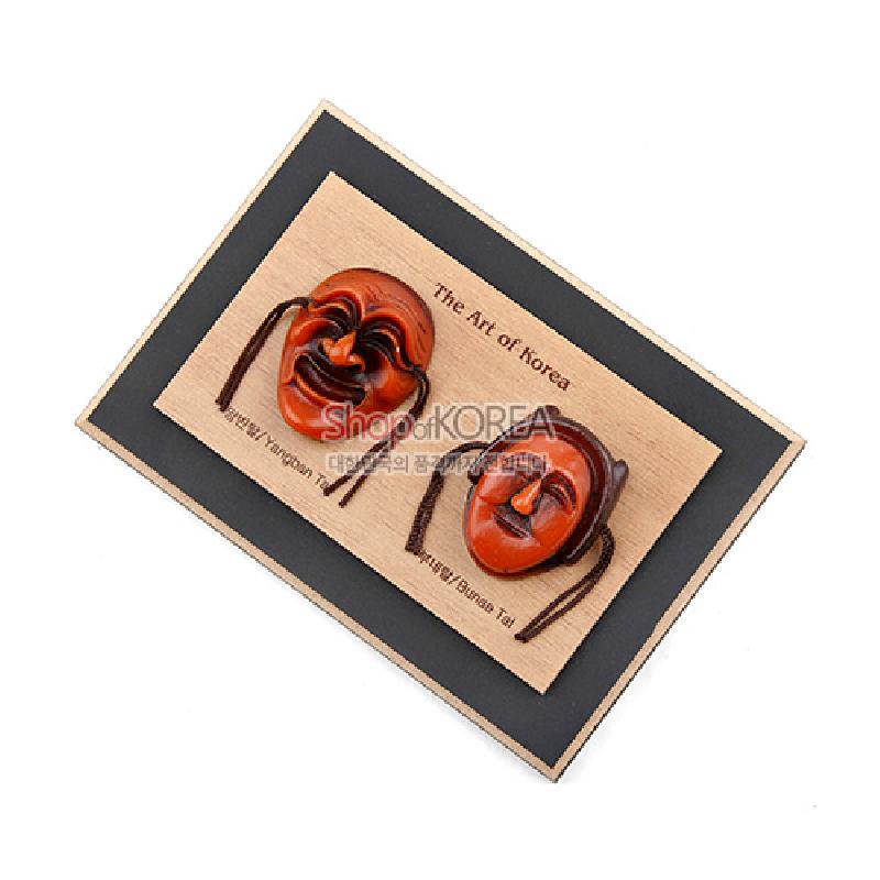 나무 바탕 위에 갈색 목조 하회탈 두 개를 부착한 가로형 액자, 검은색 테두리 배경이 조화를 이루는 장식 액자.