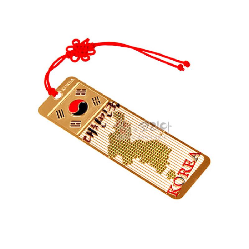 금속 재질에 금장 처리된 대한민국 지도 문양과 태극기 문양, 붉은색 매듭 장식 끈이 어우러진 책갈피.