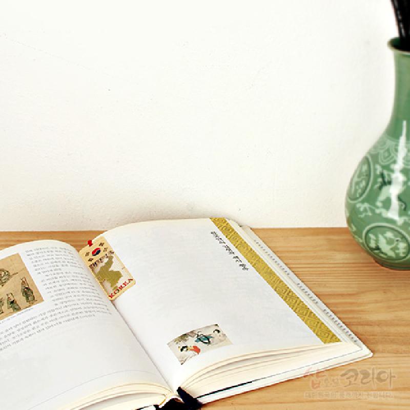 금속 재질의 얇은 책갈피에 대한민국 지도가 금장으로 표현되고 붉은색 포인트와 영문 글자가 더해진 디자인.