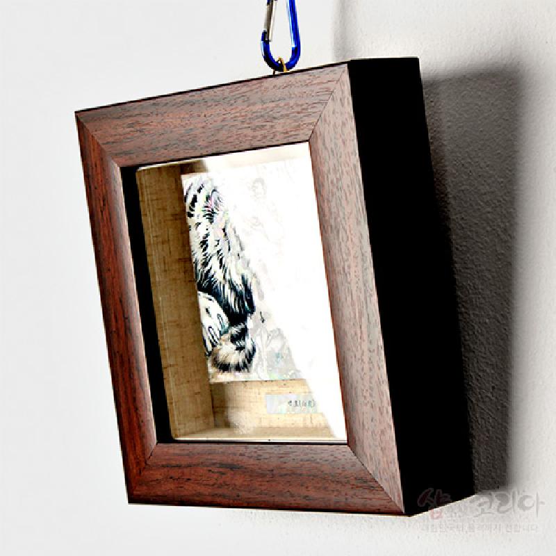 나뭇결이 살아 있는 원목 액자에 자개 상감 기법으로 표현된 백호 문양이 삽입된 미니 액자.