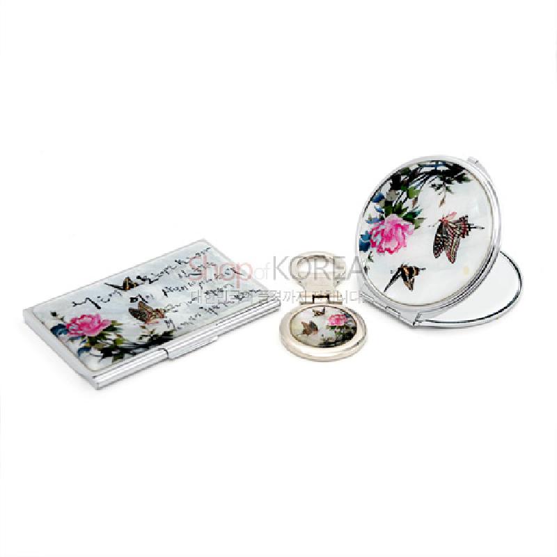 흰 바탕에 분홍 꽃과 나비 문양이 그려진 금속 명함집과 원형 거울 세트. 흰 바탕에 분홍 꽃과 나비 문양이 그려진 금속 명함집과 원형 거울 세트.