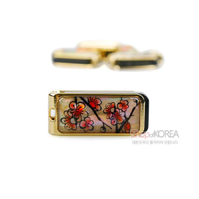 자개 바탕 위에 옻칠한 금속 케이스, 붉은 매화와 가지 문양이 장식된 USB 메모리.