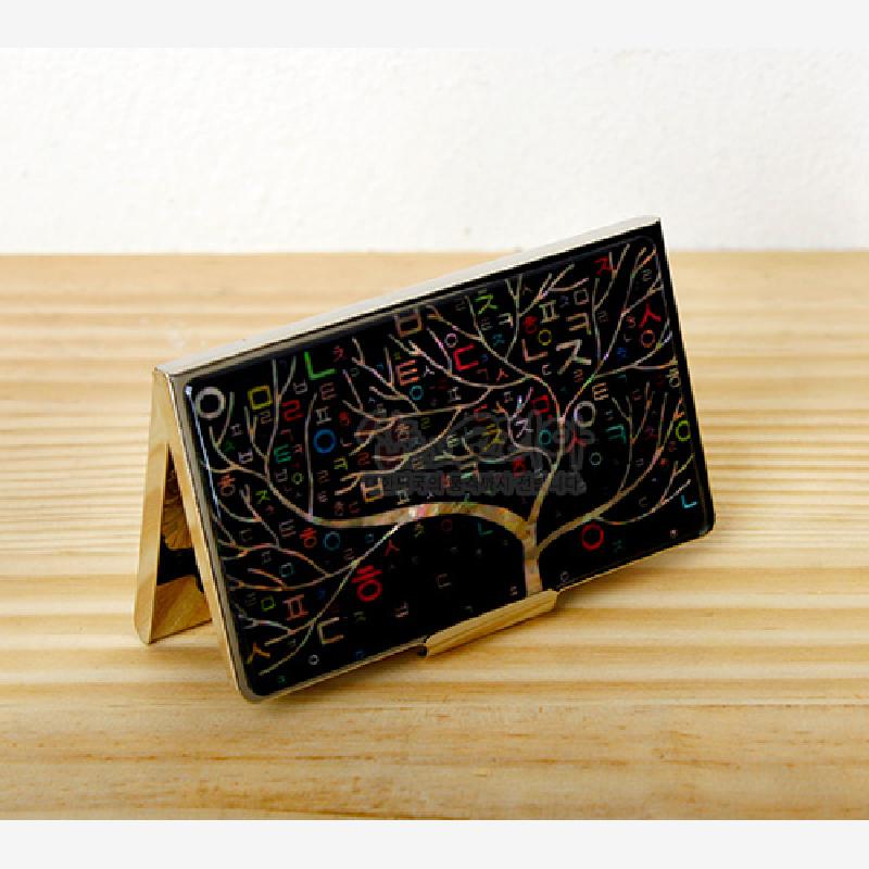 검은 바탕에 자개 상감 기법으로 표현된 나무와 다채로운 한글 자모 문양이 조화된 금속 명함집.