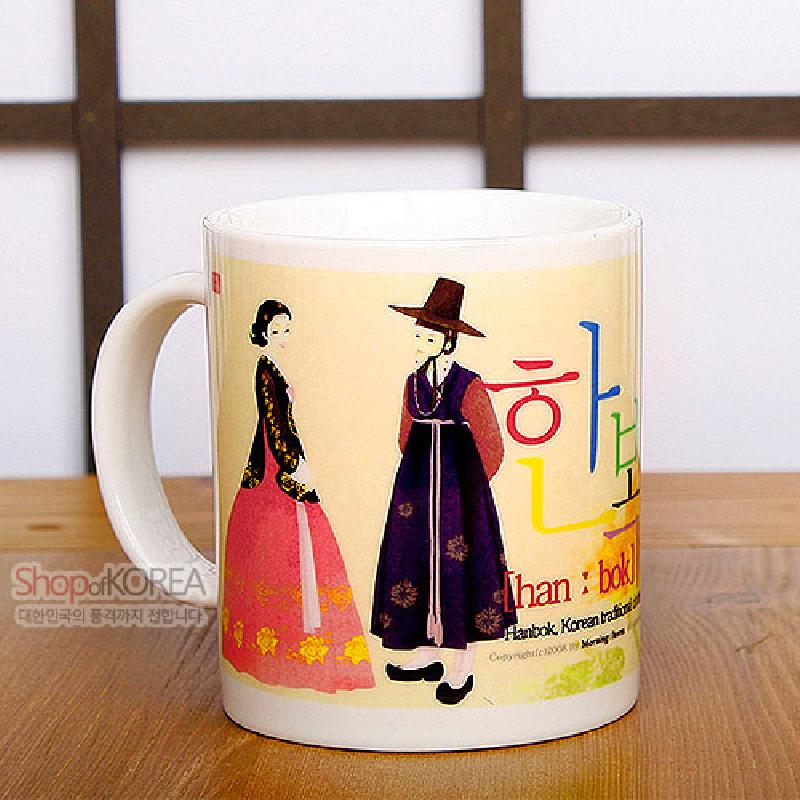 한복 차림 부부 일러스트와 한글 레터링이 파스텔톤으로 인쇄된 도자기 머그컵.