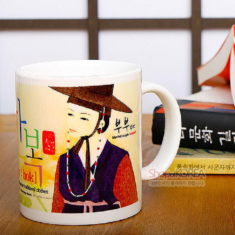 한복 차림 남편 캐릭터와 갓, 구슬 장식 목걸이 일러스트가 인쇄된 흰색 세라믹 머그컵.