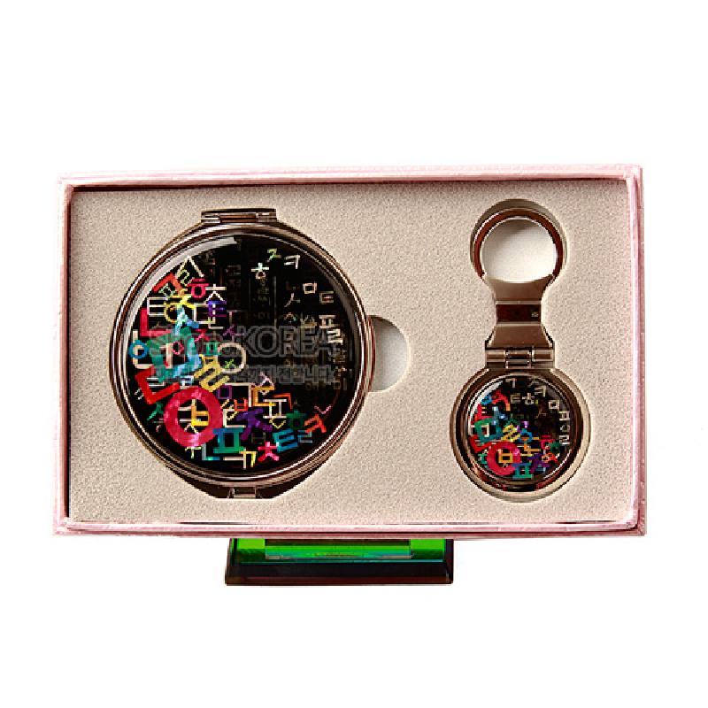 검은 바탕 위 다채로운 한글 자음 문양과 자개 장식을 넣은 금속 테두리 손거울 2종 세트.