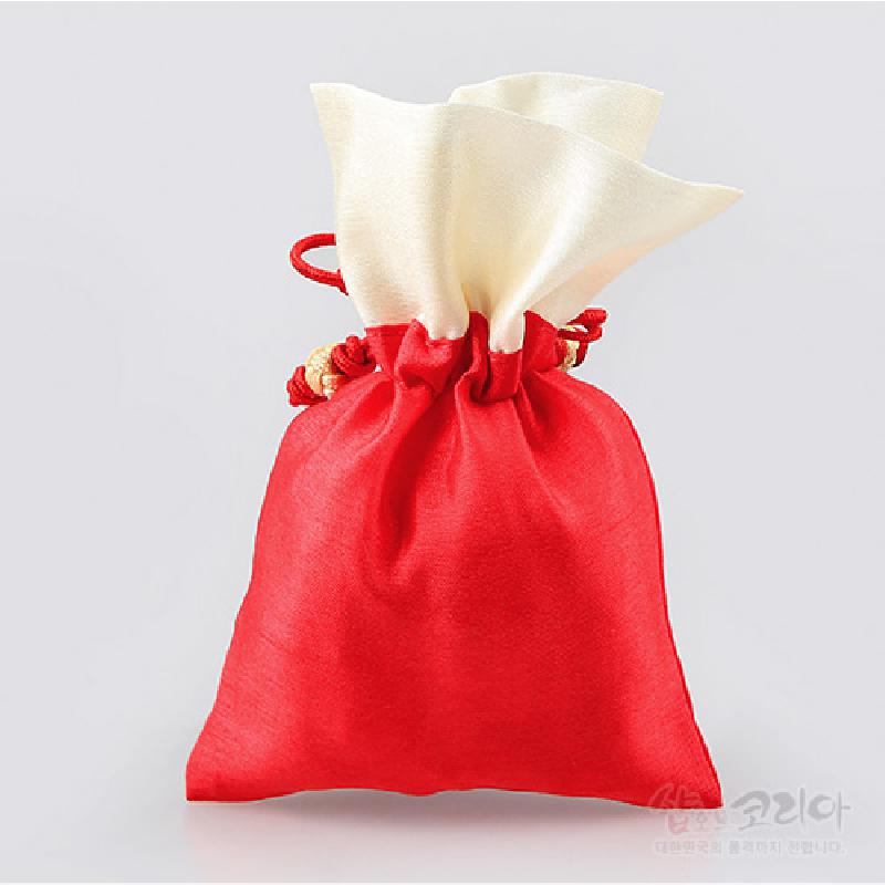 붉은색과 아이보리색 비단으로 제작된 이중 구조의 복주머니, 전통 매듭끈으로 조여 묶는 디자인.