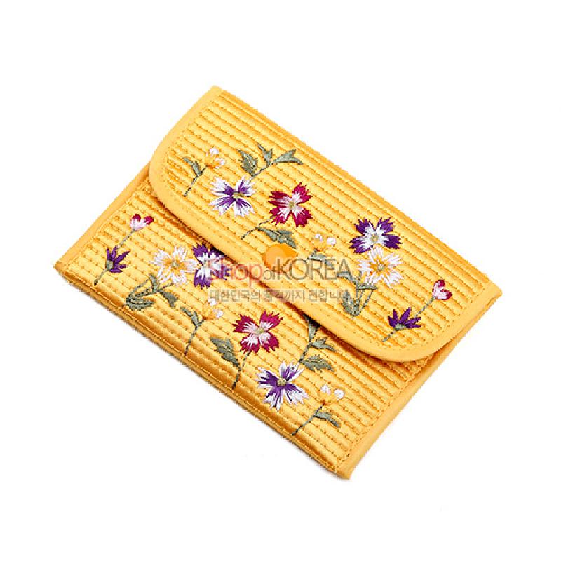 노란색 누비 천 소재에 똑딱이 단추를 사용하고, 다채로운 꽃자수 문양이 수놓인 동전지갑.