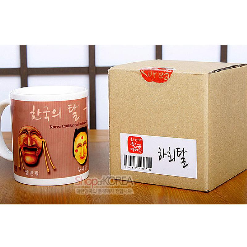 하회탈을 포함한 전통 탈 문양이 인쇄된 도자기 머그컵, 갈색 계열 배경색과 한글 서체 장식.