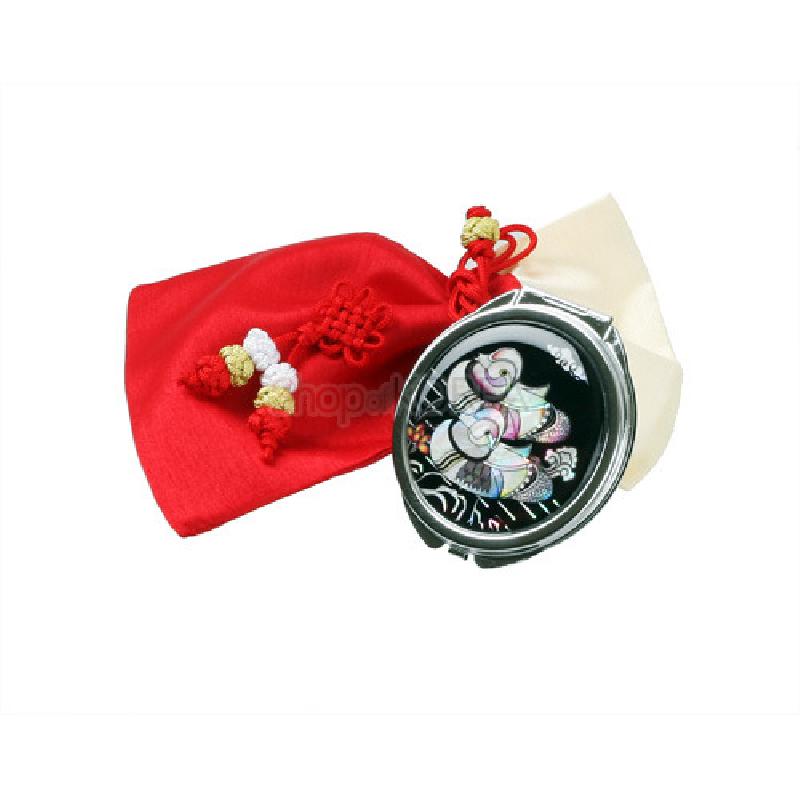 자개 상감 기법으로 검은 바탕에 원앙 문양을 넣은 금속 손거울과 붉은 비단 주머니 세트.
