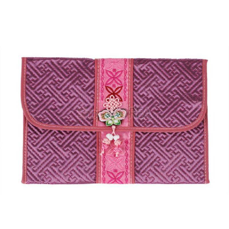 자주색 누비 원단에 기하학 무늬를 넣고, 중앙에는 분홍색 자수 띠와 전통 매듭·나비 장식을 더한 직사각형 지갑