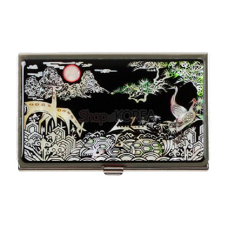 검은 바탕에 자개로 십장생 문양을 새긴 금속 명함집으로, 학·거북·소나무와 산수 풍경이 오색광으로 표현됨.