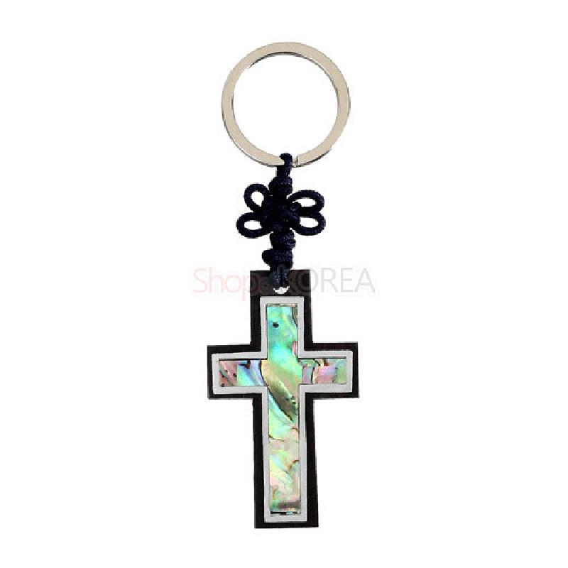 흑단 테두리에 자개를 상감한 십자가 열쇠고리로, 오색으로 빛나는 자개 문양과 남색 매듭 장식이 특징인 디자인