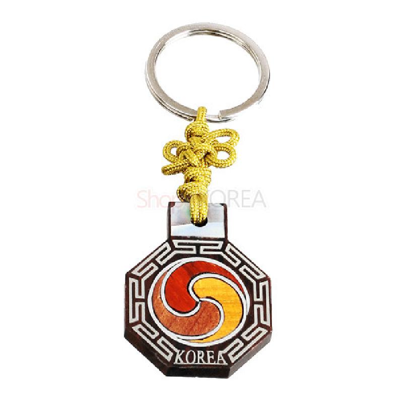 흑단 재질 팔각 펜던트에 붉은·주황 태극 문양과 백색 기하학 무늬, 노란 전통 매듭이 장식된 열쇠고리