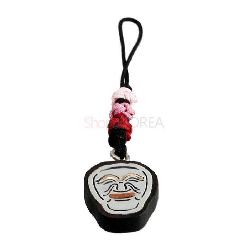 흑단 바탕에 흰색 양반탈 문양을 새긴 펜던트와 분홍·붉은 매듭 장식이 어우러진 열쇠고리.