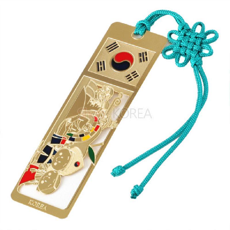 금속 재질에 태극기 문양과 금장 선각 캐릭터, 오방색 포인트가 어우러진 책갈피형 장식.