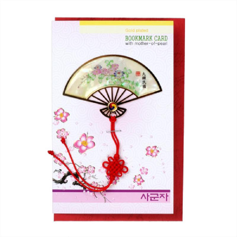 자개 상감으로 국화와 꽃무늬를 표현한 부채 형태 금속 책갈피와 붉은 전통매듭 장식 카드.