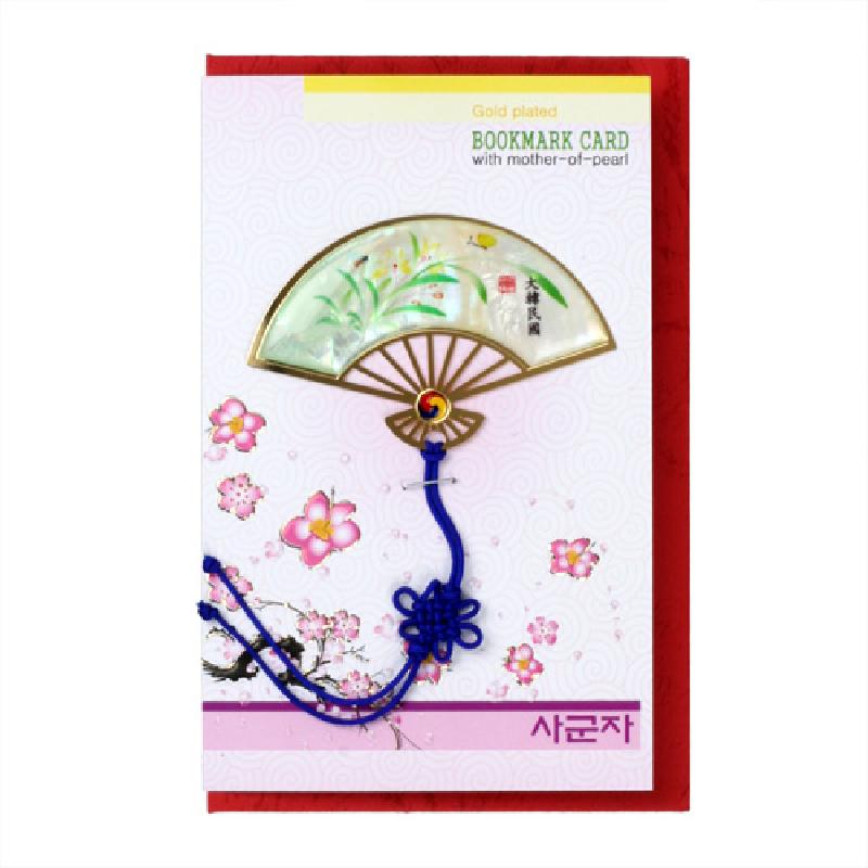 자개를 상감한 반달 부채 모양 금속 책갈피, 옻칠 바탕에 난초 문양과 청색 전통 매듭 장식.