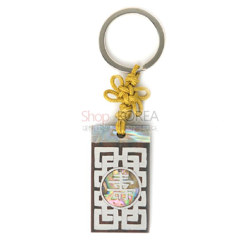 흑단 바탕에 자개 상감으로 수문과 길상문을 새긴 직사각 장식, 노란 전통 매듭 끈과 금속 고리 결합 열쇠고리.