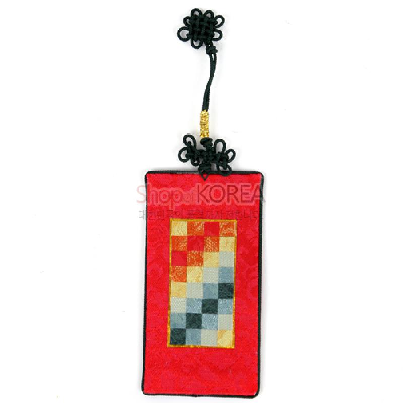 붉은 비단 바탕에 다채로운 색상의 조각보 누비 패턴이 들어간 직사각 책갈피와 흑색 전통 매듭 장식.