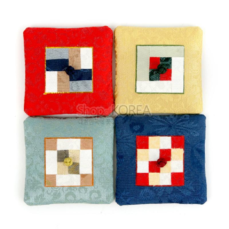 비단 원단 위에 전통 조각보 누비 기법으로 사각 패치 장식을 더하고 중앙 매듭 단추를 배치한 자석 장식.